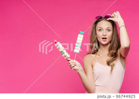 Funny girl holding marshmallows on stick under Funny girl holding marshmallows on stick under 86744925