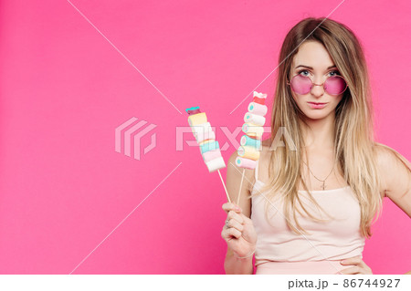 Funny girl holding marshmallows on stick under Funny girl holding marshmallows on stick under 86744927