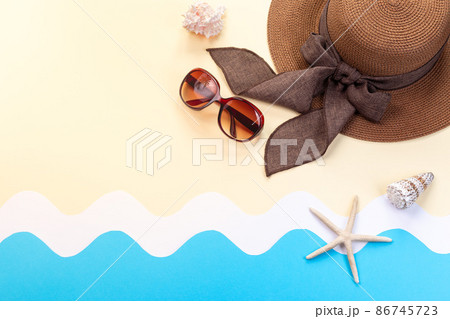 Summer background with hat, sunglasses and seashells, waves made from paper, horizontal, top view copy space 86745723