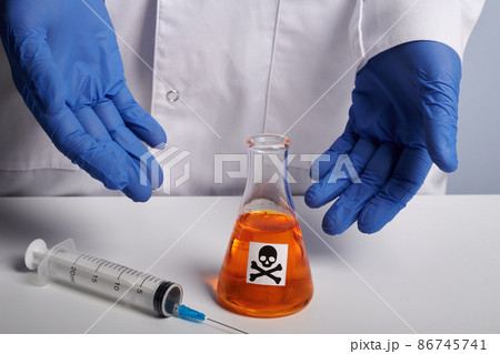 Doctor Shows Orange Poison Retort and Syringe - Labs Photo 86745741
