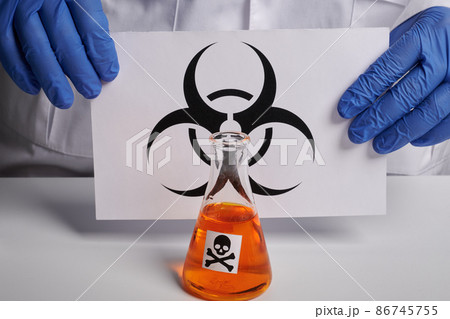 Doctor Shows Biohazard Symbol on Page and Orange Toxin - Labs Photo 86745755