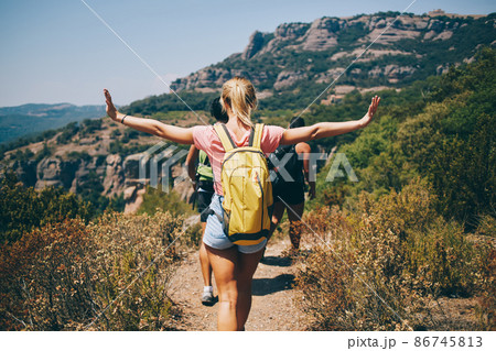 Woman spreading arms and hiking on sunny day Woman spreading arms and hiking on sunny day 86745813