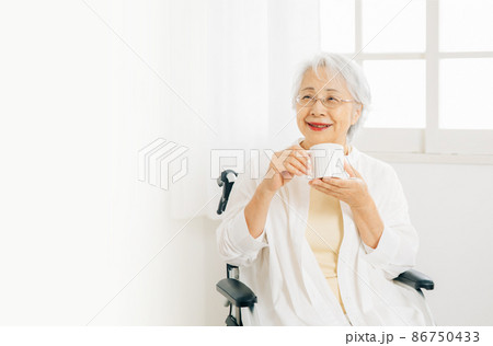 部屋でドリンクを飲む高齢者女性 部屋でドリンクを飲む高齢者女性 86750433