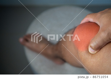 The man holds his pain point of knee joint. The red point shows position of Injury. 86751054