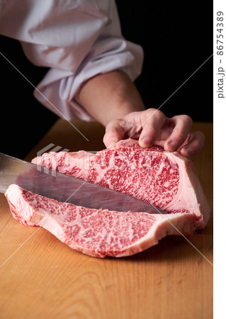 サーロインステーキを包丁でカットする料理人　国産黒毛和牛 86754389