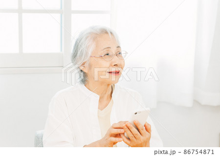 スマホを使う高齢者女性（笑顔） 86754871