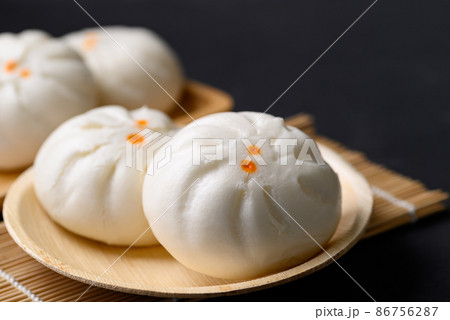 Steamed Chinese bun stuffed with minced pork, egg yolk or sweet on natural plate, Asian food Steamed Chinese bun stuffed with minced pork, egg yolk or sweet on natural plate, Asian food 86756287