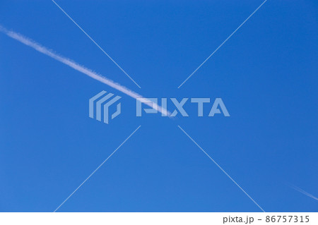 真っ青な空に引かれた飛行機雲 86757315