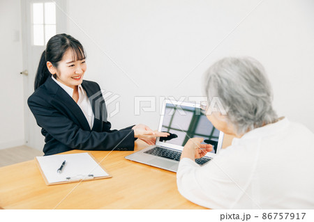 打ち合わせするスーツ姿の女性と高齢者女性 86757917