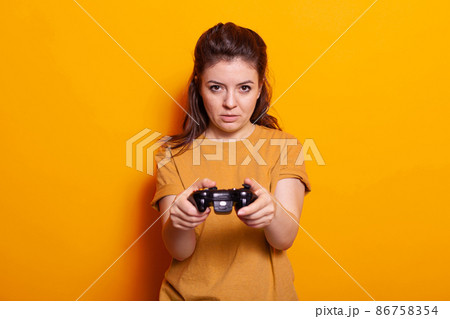 Portrait of woman holding controller in front of camera 86758354