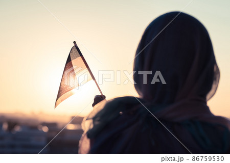 Muslim woman in scarf with Germany flag of at sunset.Concept 86759530