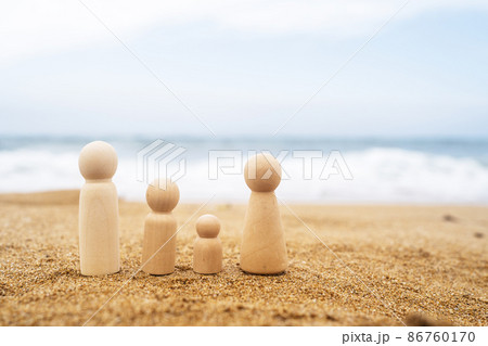 Wooden four figures of people on the sand of beach with sea view. Happy family with two kids on holiday. Wooden four figures of people on the sand of beach with sea view. Happy family with two kids on holiday. 86760170