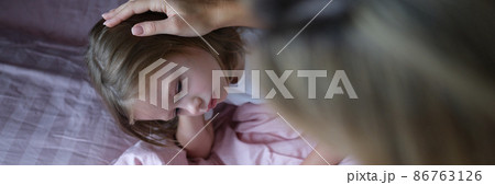 Mom puts sad girl on head before going to bed. 86763126