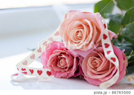 Roses with gift ribbon. Closeup. Valentines day. Roses with gift ribbon. Closeup. Valentines day. 86765000