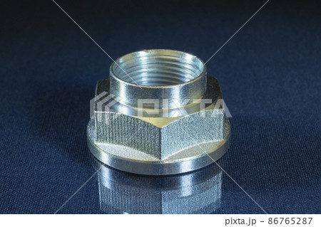 Metal nut with thread on the table with reflection Metal nut with thread on the table with reflection 86765287