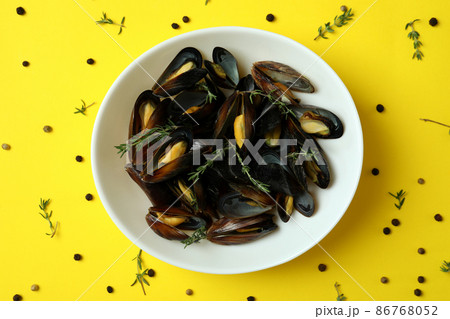 Bowl with fresh mussels on yellow background 86768052