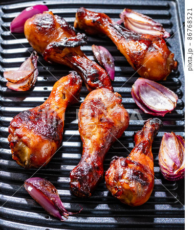 Grilled chicken drumsticks and red onion 86768521