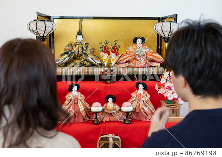 飾ったおひな様の前で座っている若い夫婦 飾ったおひな様の前で座っている若い夫婦 86769198