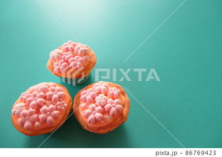グリーン背景に桜のカップケーキのスイーツデコ グリーン背景に桜のカップケーキのスイーツデコ 86769423