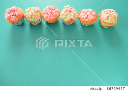 グリーン背景に桜のカップケーキのスイーツデコ グリーン背景に桜のカップケーキのスイーツデコ 86769427