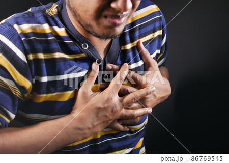 young man suffering pain in heart and holding chest with hand young man suffering pain in heart and holding chest with hand 86769545