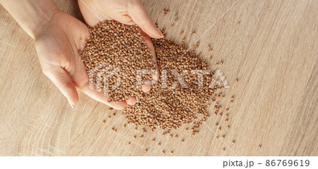 raw buckwheat in hands 86769619