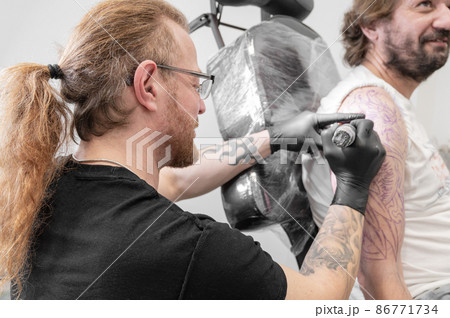 Salon tattoo. Close up of a Tattoo artist working. Tattoo artist make tattoo at the studio. 86771734