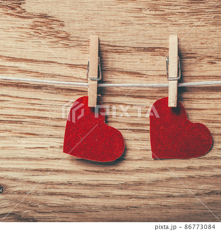 two red hearts on clothespins on wooden background two red hearts on clothespins on wooden background 86773084