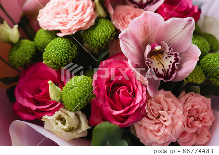 Bright pink flowers bouquet closeup. Roses and orchids wallpaper. Beautiful background for a Birthday, International Female Day, or Saint Valentine. The festive backdrop for a postcard design 86774483