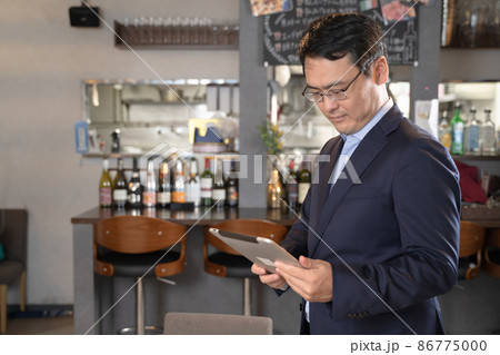 タブレットを持ってレストランを経営する男性 86775000