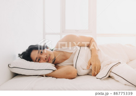 Man just wake up in a happy morning in bright white bedroom. 86775339