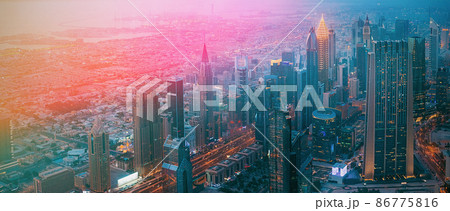 Aerial View Of Evening Night Scenic View Of Skyscraper. Street Night Illumination. Waterfront And Dubai Cityscape In Summer Evening. Night Scenic View Of Dubai Skyline. Film effect, lens flare, glow 86775816