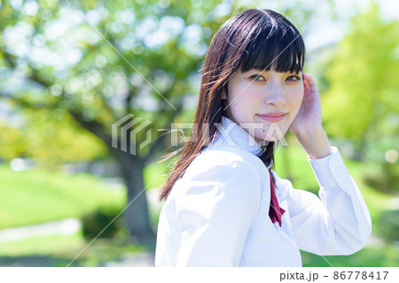 綺麗な新緑の学校の登下校の途中で髪をかき上げながらこちらを見る女子高校生 通学登校下校 上半身 綺麗な新緑の学校の登下校の途中で髪をかき上げながらこちらを見る女子高校生 通学登校下校 上半身 86778417