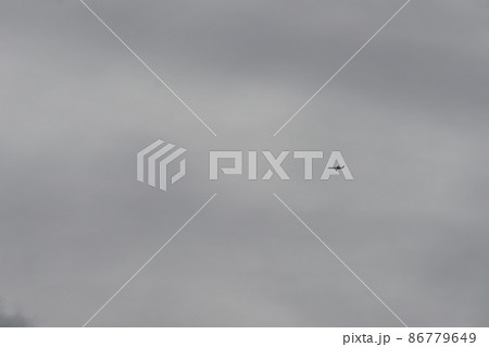 曇り空を飛ぶ小さく見える飛行機のある冬の空の風景 曇り空を飛ぶ小さく見える飛行機のある冬の空の風景 86779649
