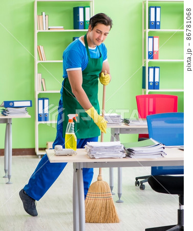 Young male handsome professional cleaner cleaning floor with bro 86781068