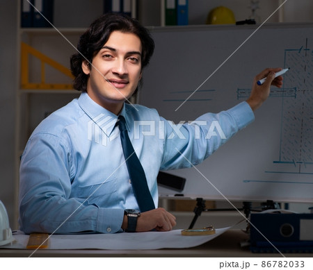 The young male architect working night at office The young male architect working night at office 86782033
