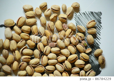 Top view of Pistachio nuts in wooden bowl on checkered cloth. High quality photo Top view of Pistachio nuts in wooden bowl on checkered cloth. High quality photo 86784229