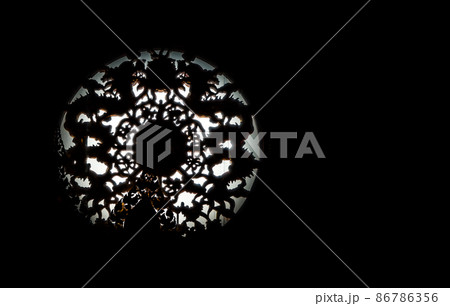 Twin Chinese dragons sculpture decorate on chinese-style circular window through which a ray of light passes. 86786356