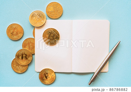 Bitcoin on empty notebook and pen on pastel color background.  86786882