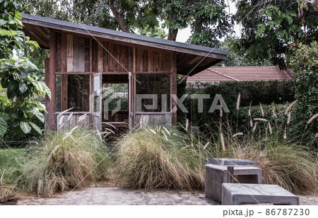Nice small wooden hut. Green garden joy in summer with Stone benchs and perennial ryegrass plant. Nice small wooden hut. Green garden joy in summer with Stone benchs and perennial ryegrass plant. 86787230