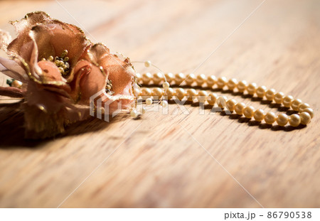 オレンジ色のコサージュとパールのネックレス 86790538