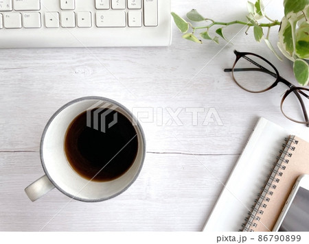 デスクの上の小物とコーヒーの入ったマグカップ 86790899