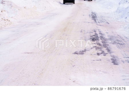 道路脇に雪が寄せられ道幅が狭くなる車道　北海道 86791676
