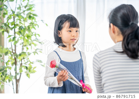 母の日にカーネーションを母親に渡す女の子 86791715