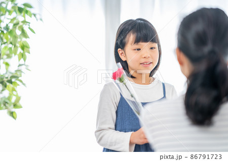 母の日にカーネーションを母親に渡す女の子 86791723