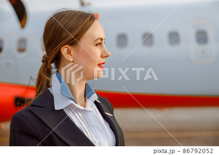 Female flight attendant standing outdoors at airfield 86792052
