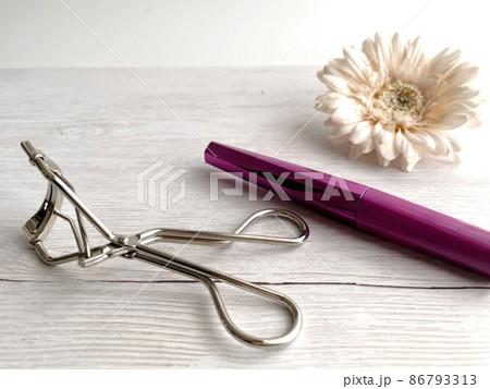 机の上に置いたビューラーとマスカラと白い花 机の上に置いたビューラーとマスカラと白い花 86793313
