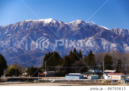 冬の南アルプス　農村と南アルプス鳳凰三山の風景　北杜市から　山梨県 86793615