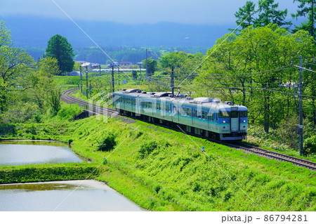 信州信濃町古間地区 黒姫駅付近の新緑を走るしなの鉄道 86794281