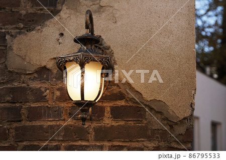 Lantern on brick wall of old city. Real photo in the city. Lantern on brick wall of old city. Real photo in the city. 86795533